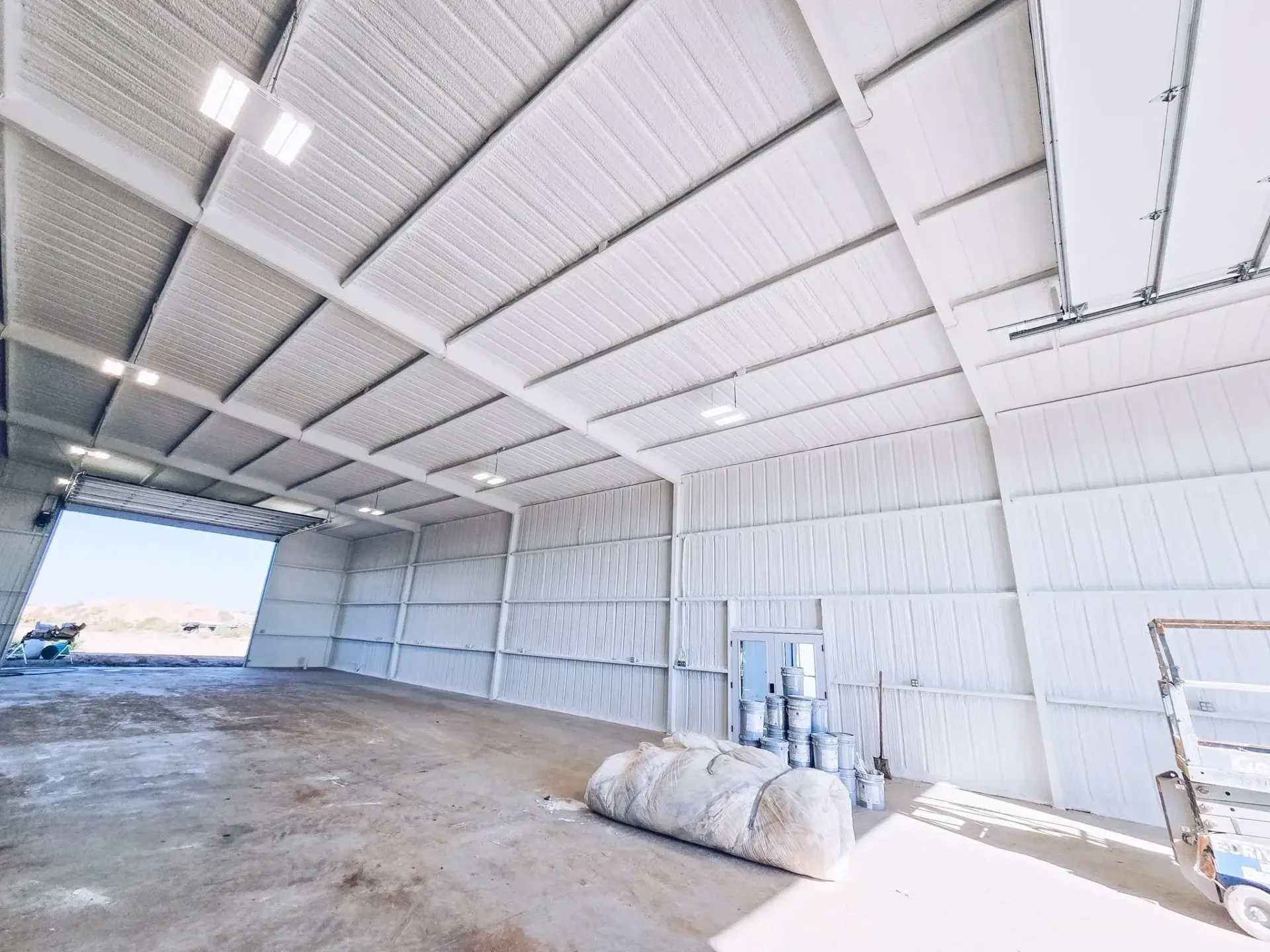 Empty industrial warehouse interior with spray foam insulation on walls and ceiling